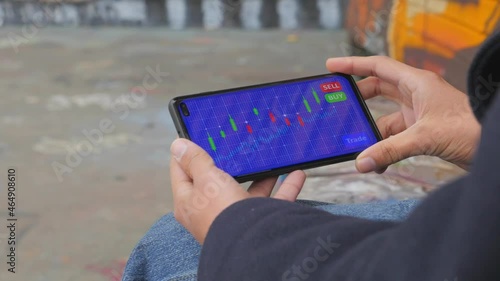 Young female analyzes a cryptocurrency stock market chart on her mobile phone