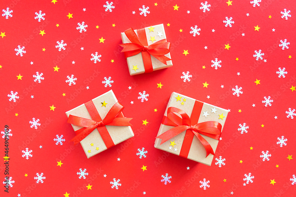 Three New Year's gifts with white snowflakes and stars on a red background. Christmas background, flat lay. Three New Year's gifts with white snowflakes and stars on a red background. Christmas background, flat lay.