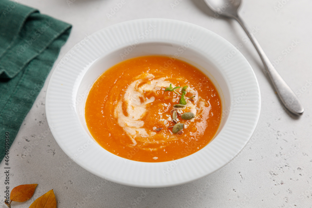 pumpkin soup with seeds and cream in a white plate on a gray table pumpkin soup with seeds and cream in a white plate on a gray table