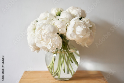 Fototapeta Naklejka Na Ścianę i Meble -  White peonies in a glass vase. Beautiful peony flower for catalog or online store. Floral shop concept . Beautiful fresh cut bouquet. Flowers delivery