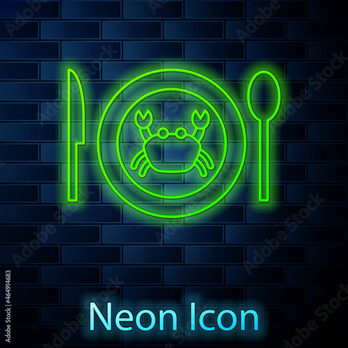 Glowing neon line Served crab on a plate icon isolated on brick wall background. Vector.