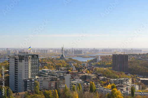 Beautiful panorama of autumn Kiev. View from the left bank to the Dnieper. Wide river in the city and autumn yellow trees.Village and city