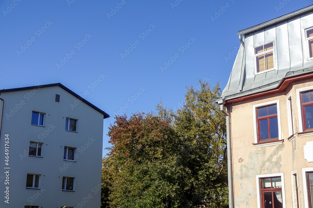 Close up of white houses with clear blue sky background with an autumn foliage on the back. Pelgulinna, Tallinn, Estonia, Europe. September 2021 Close up of white houses with clear blue sky background with an autumn foliage on the back. Pelgulinna, Tallinn, Estonia, Europe. September 2021