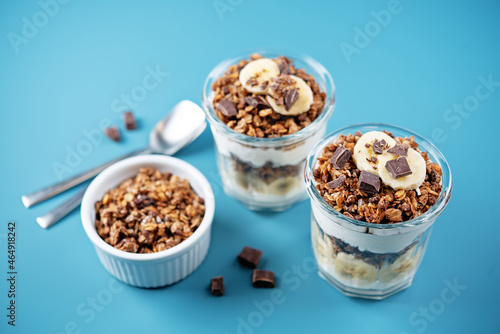 Chocolate and banana Greek yogurt granola parfait in a glass