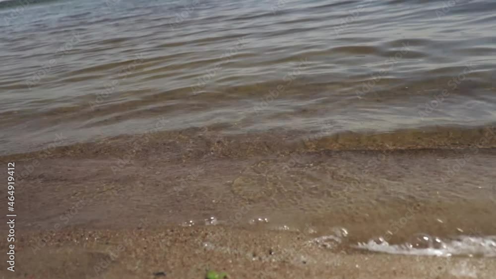 lake, river, water, beach, weak waves, the foam of the waves, feet on the sand, sandy beach, a man walks on the sand, surrounded by waves lake, river, water, beach, weak waves, the foam of the waves, feet on the sand, sandy beach, a man walks on the sand, surrounded by waves