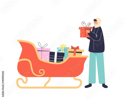 Girl taking gift box from santa sleigh. Christmas presents in sledge decoration for exterior