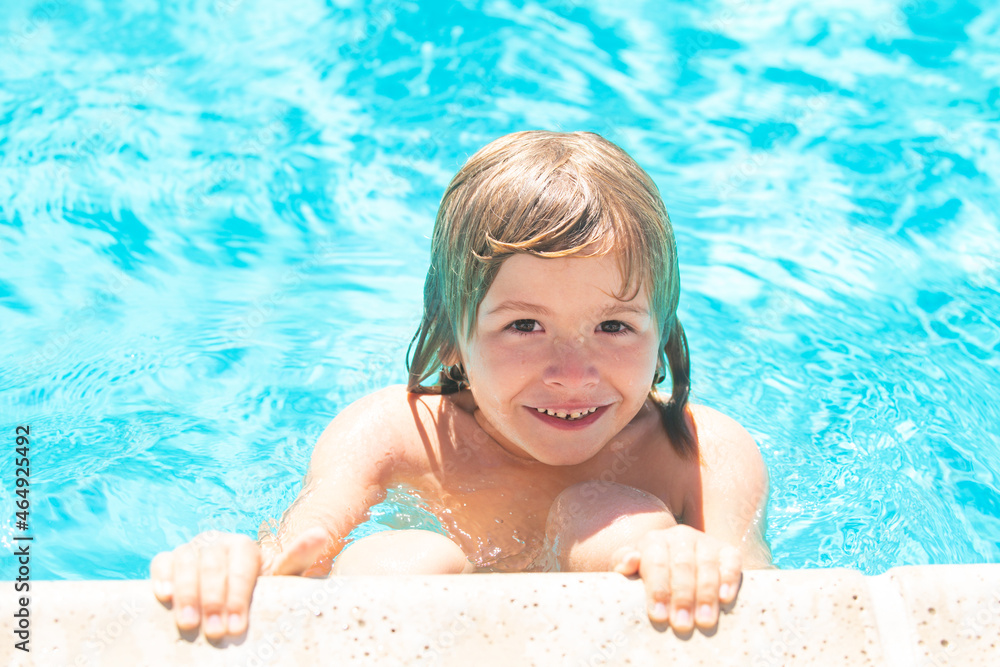 Kid in swimming pool. Little boy playing in outdoor swimming pool in