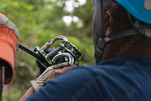  una persona afroamericana no reconocible con una polea de soporte y equipo de seguridad para cables de canopy en Costa Rica 