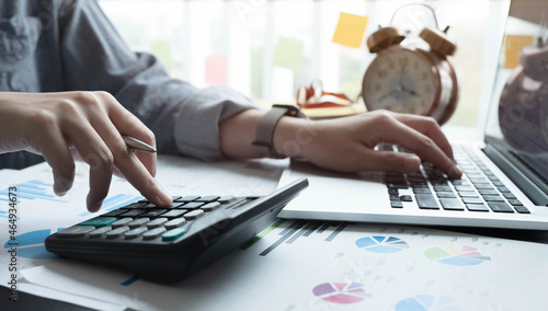 Fototapeta Naklejka Na Ścianę i Meble -  Close up Businesswoman using calculator and laptop for calaulating finance, tax, accounting, statistics and analytic research concept