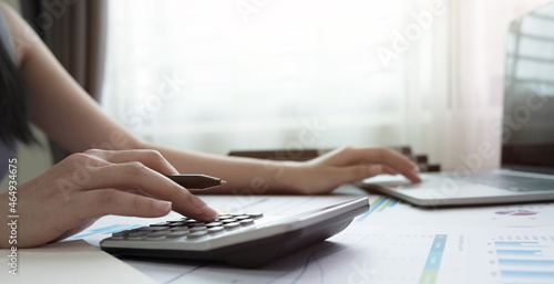 woman using calculator for calaulating finance, tax, accounting, statistics and analytic reserch concept photo