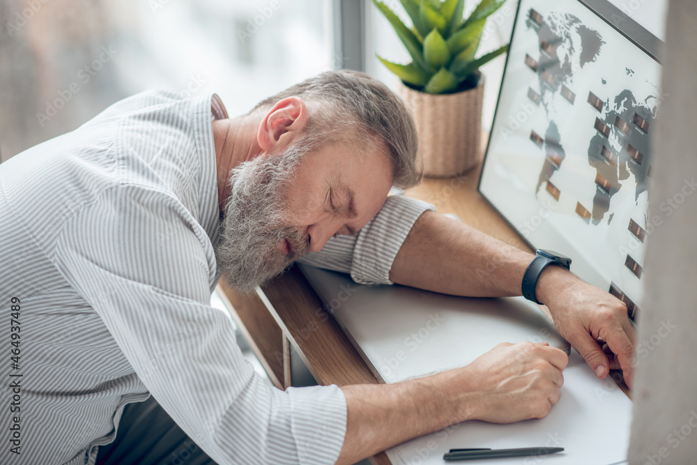 Obraz premium A man sleeping at the working place feeling tired