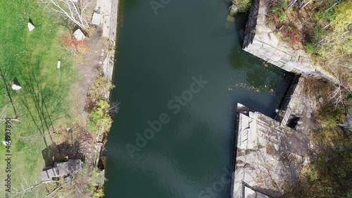 Quick vertical aerial reveals steep, narrow, flooded old marble quarry photo