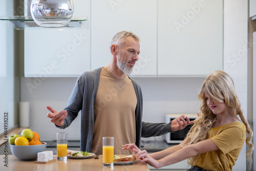 Dad trying to make his daughter eat breakfast
