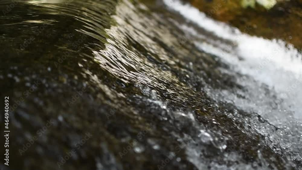 close up of water stream flowing through rocks at waterfall close up of water stream flowing through rocks at waterfall