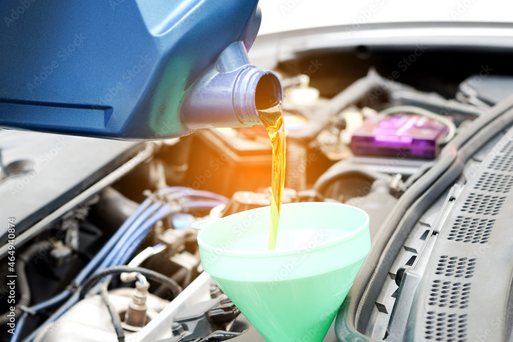 Refueling and pouring oil quality into the engine motor car Transmission and Maintenance Gear .Energy fuel concept. Refueling and pouring oil quality into the engine motor car Transmission and Maintenance Gear .Energy fuel concept.
