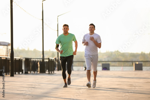 Sporty young men running ou...