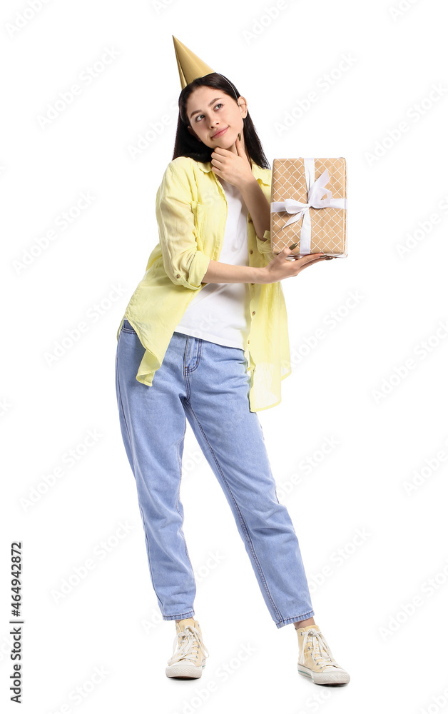 Thoughtful teenage girl in party hat with gift box on white background Thoughtful teenage girl in party hat with gift box on white background