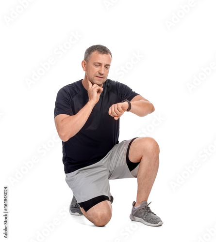Male runner checking pulse on white background