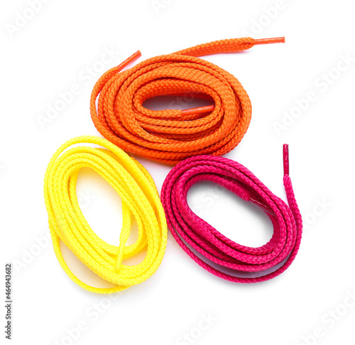 Rolls of colorful shoe laces on white background