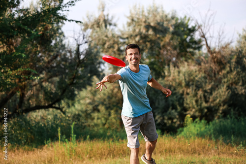 Canvas Print Young man throwing frisbee in park