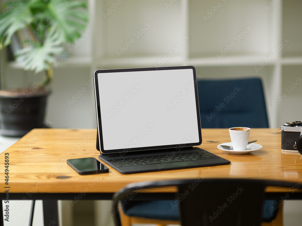 Modern portable tablet with keyboard in blank screen mockup stand on wooden table Modern portable tablet with keyboard in blank screen mockup stand on wooden table
