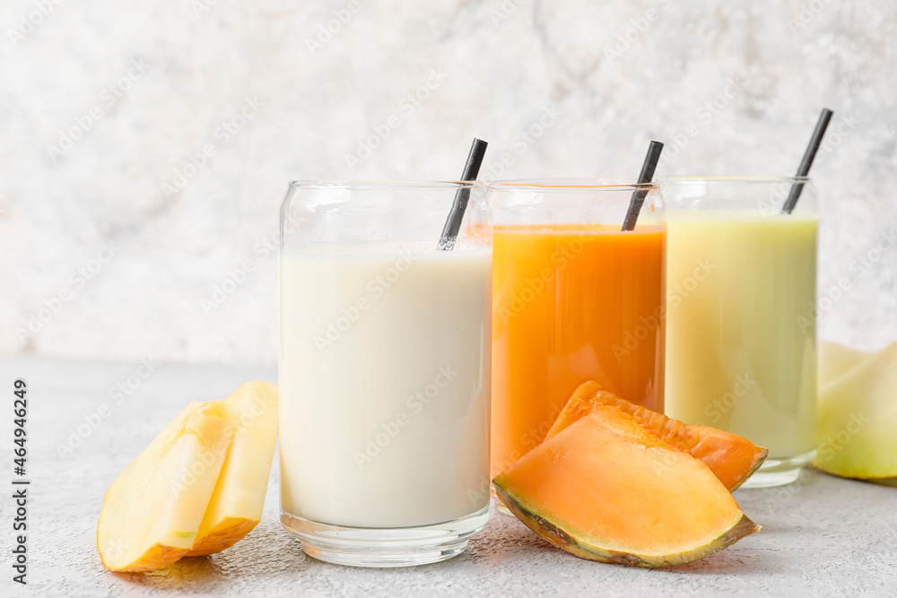 Glasses of tasty melon milkshake on light background, closeup