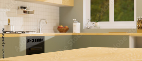 Wooden kitchen counter island for montage over blurred vintage green kitchen interior background.