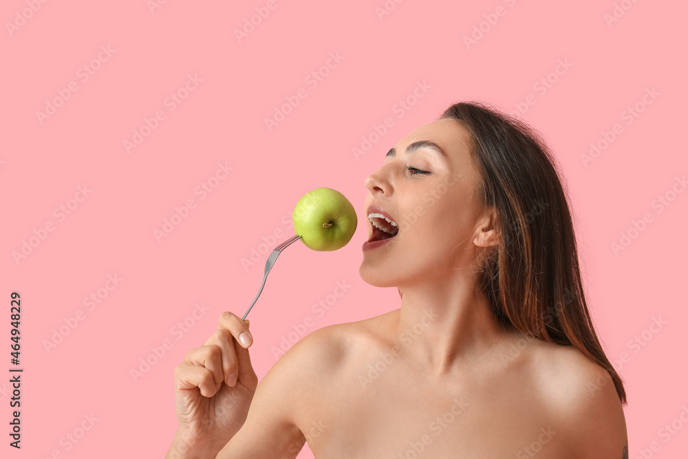 Naked young woman with fresh apple on color background. Vegan Day Naked young woman with fresh apple on color background. Vegan Day