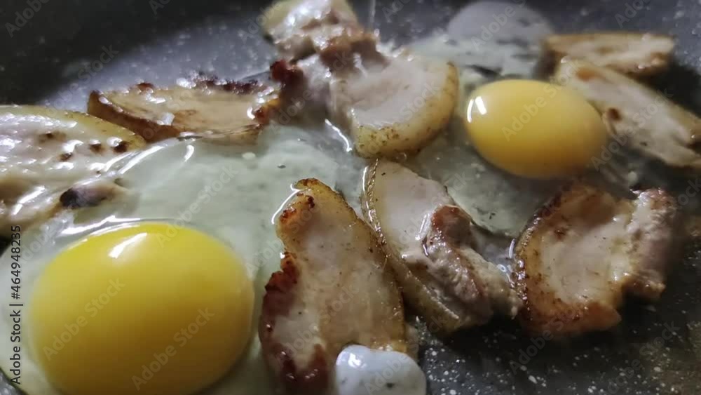 Cooking hot meals. Scrambled eggs and bacon are fried in a kitchen pan. Prepare a hearty breakfast. Cooking hot meals. Scrambled eggs and bacon are fried in a kitchen pan. Prepare a hearty breakfast.