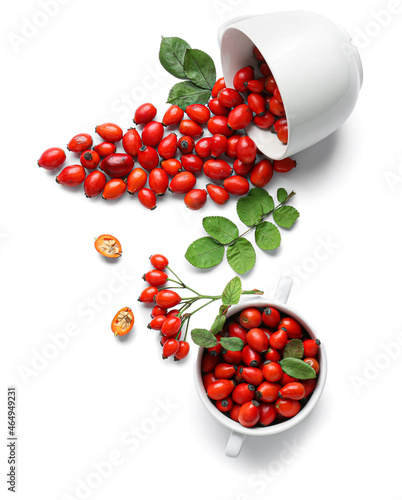 Bowls with fresh rose hip berries on white background photo
