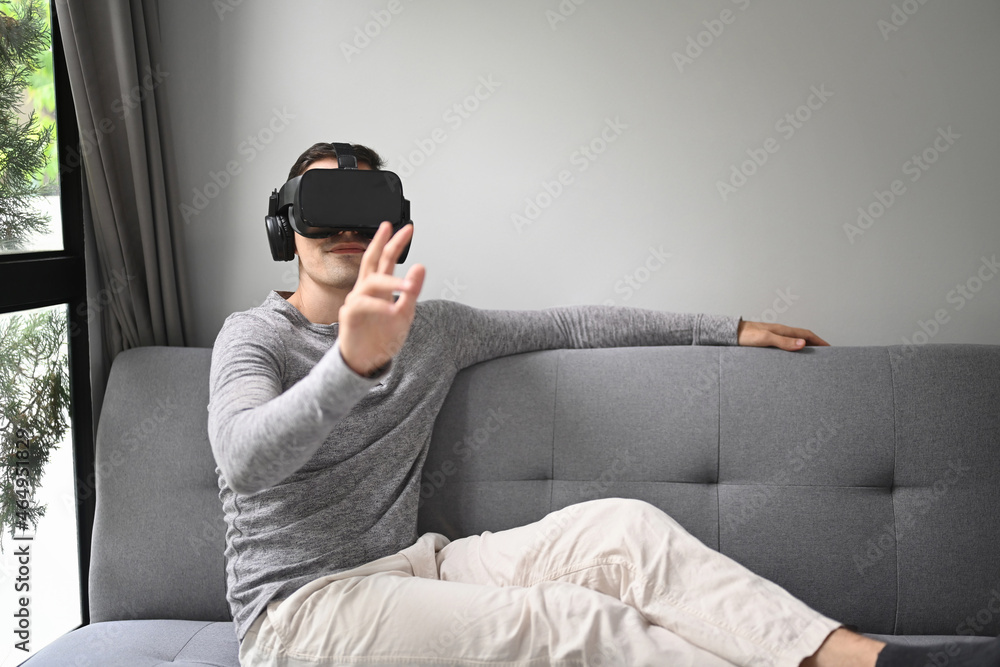 Young wearing virtual reality headset and playing video game or watching movie at home. Young wearing virtual reality headset and playing video game or watching movie at home.