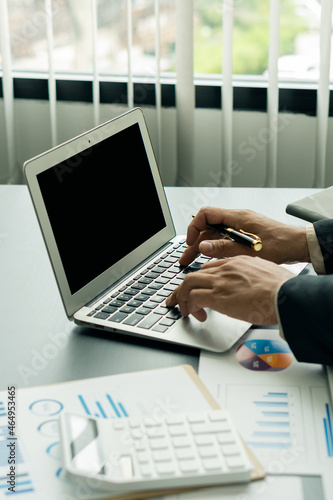 Wallpaper Mural Portrait of an accountant using the calculator and holding pen in hand making money and calculating expenses at the home office on the desk. in the finance and accounting concept office Torontodigital.ca