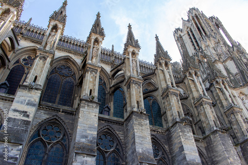 Close up view of the ornate medieval Our Lady of Reims Cathedral (Notre-Dame de Reims) in France, with high Gothic architecture, showing its flying buttresses photo