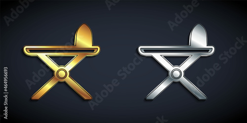 Gold and silver Electric iron and ironing board icon isolated on black background. Steam iron. Long shadow style. Vector