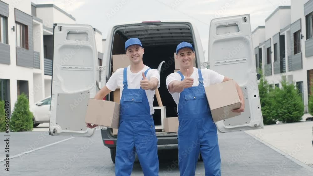 Two young workers of removal company deliver boxes to a customer's home Two young workers of removal company deliver boxes to a customer's home