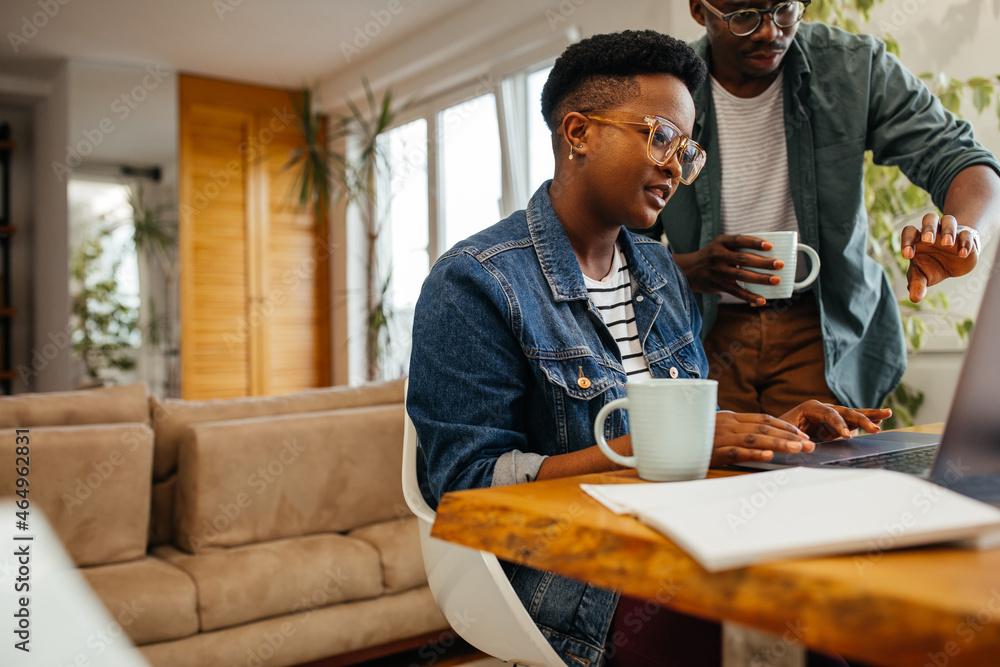 Two black workers in the home office, using technology Two black workers in the home office, using technology