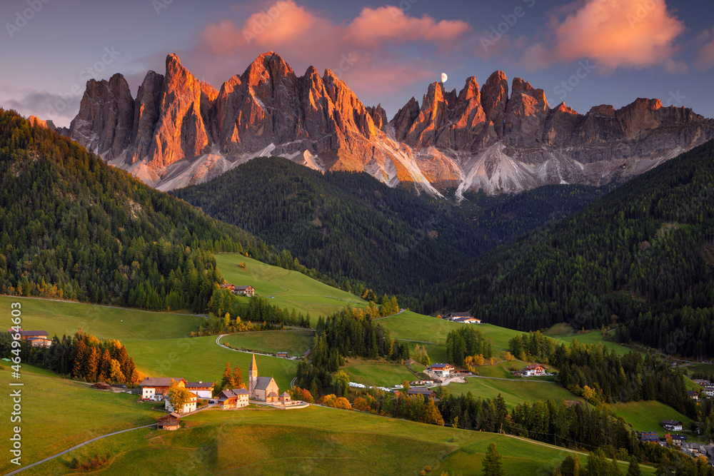 Autumn in Alps. Beautiful St. Magdalena village with magical Dolomites mountains in a gorgeous Val di Funes valley, South Tyrol, Italian Alps at autumn sunset.