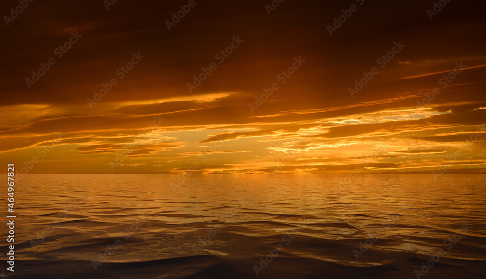 Dramatic sunset sky with clouds reflected in water surface.