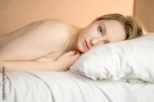 Close up portrait of a beautiful young lady lying on the bed.