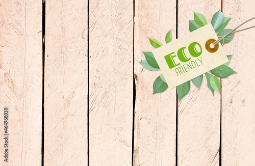 Horizontal background with eco paper label and green leaves on wooden boards