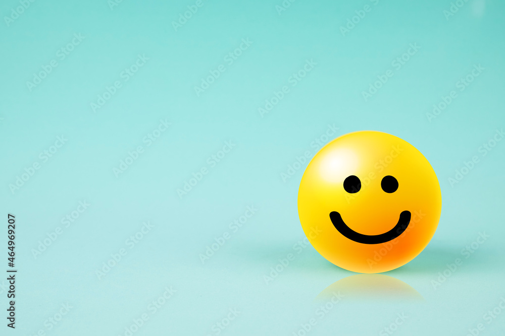 Happy smiley face emoticon with copy space on blue background	