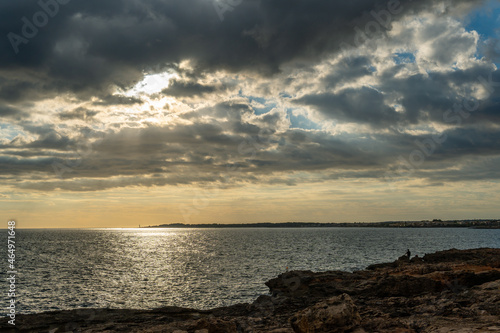 Sunset on the rocky coast of the island of Mallorca, a cloudy autumn day. Sa Rapita, Mallorca, Spain