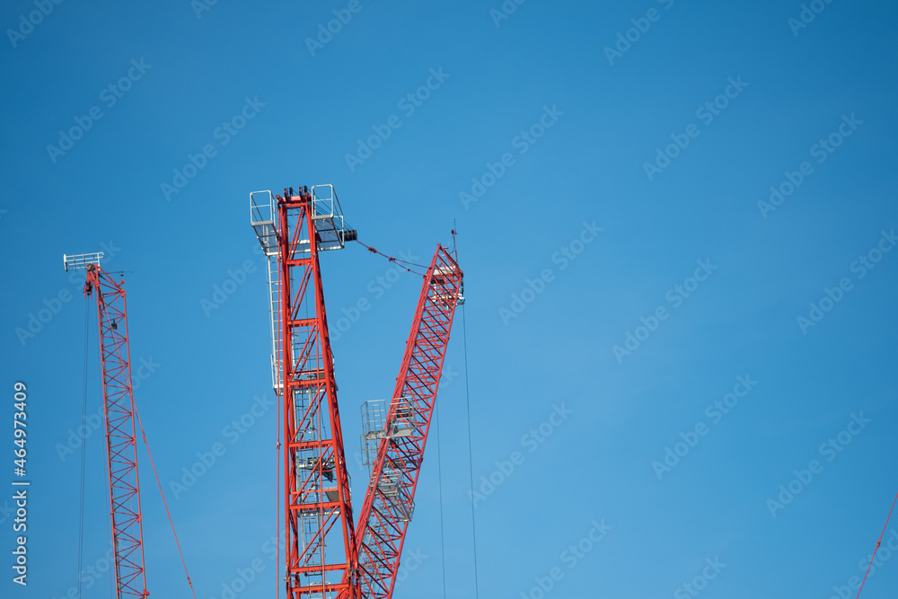 Red tower crane against blue sky background Red tower crane against blue sky background