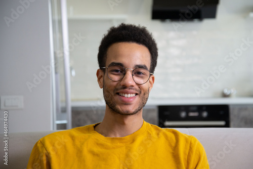 An African American man in a yellow sweater smiles. Stays at home. photo