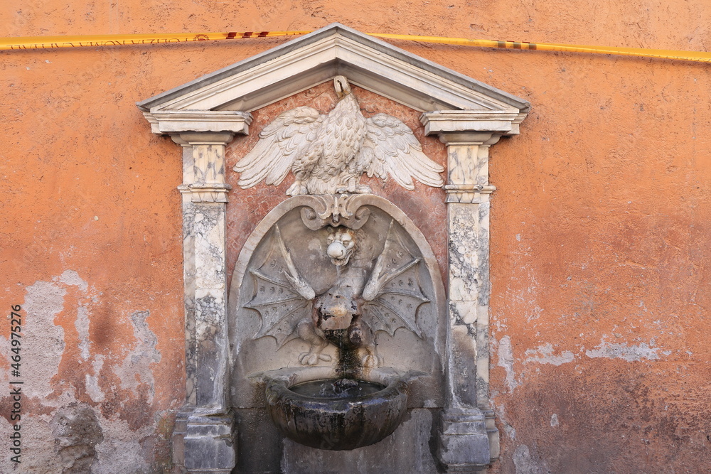 Via della Conciliazione Street Fountain with Sculpted Bird and Dragon against a Pink Aged Wall in Rome, Italy