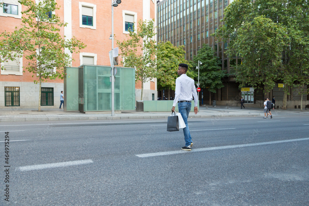 custom made wallpaper toronto digitalyoung black man shopping with paper bags crossing the street