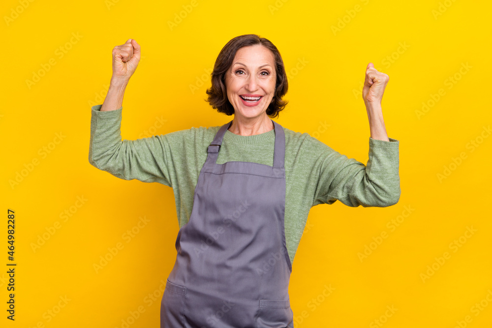 Portrait of attractive cheerful grey-haired lucky woman helper rejoicing yes goal isolated over bright yellow color background Portrait of attractive cheerful grey-haired lucky woman helper rejoicing yes goal isolated over bright yellow color background