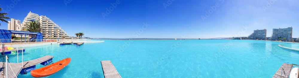 Panoramic beach behind pool in a summer day
