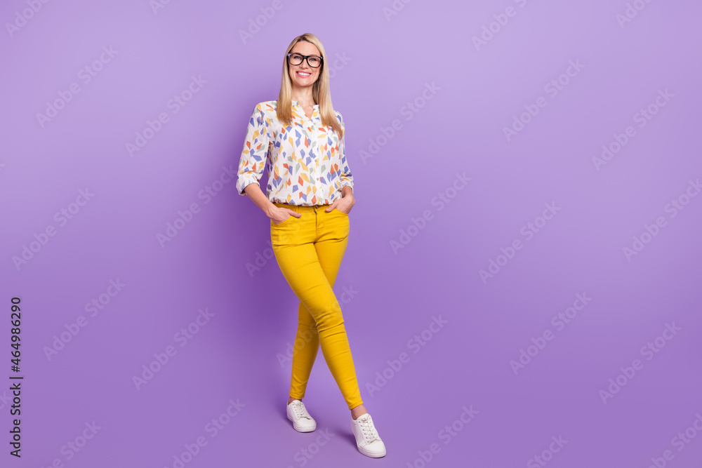 Photo of pretty adorable mature lady dressed print blouse glasses empty space walking smiling isolated purple color background Photo of pretty adorable mature lady dressed print blouse glasses empty space walking smiling isolated purple color background