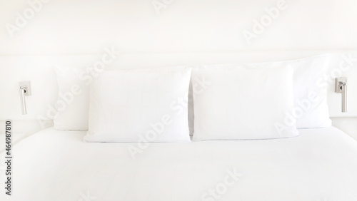 Close up of white pillows on the bedroom on a bed with duvet case bedspread isolated on white background © SASITHORN
